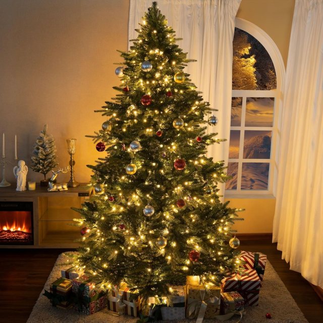 Cynthia 7.5-foot pre-lit artificial Christmas tree decorated with red, gold, and silver ornaments and warm white lights in a cozy holiday living room.