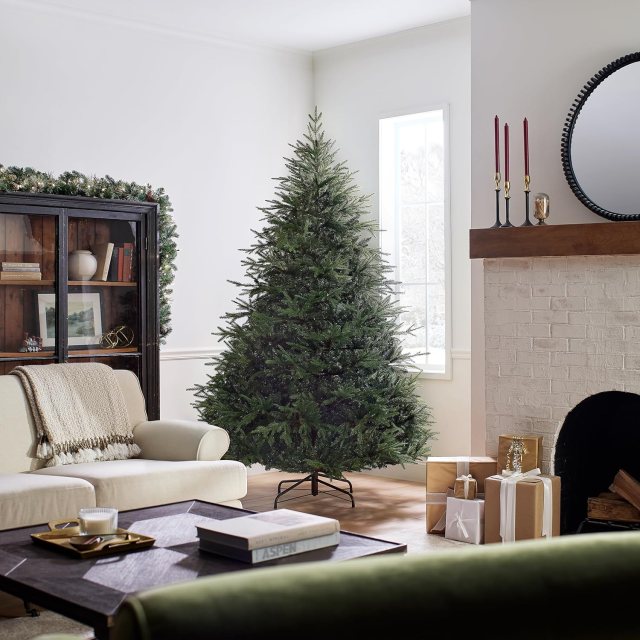 National Tree Company 7.5-foot unlit Fraser Grande artificial Christmas tree with full green branches displayed in a living room