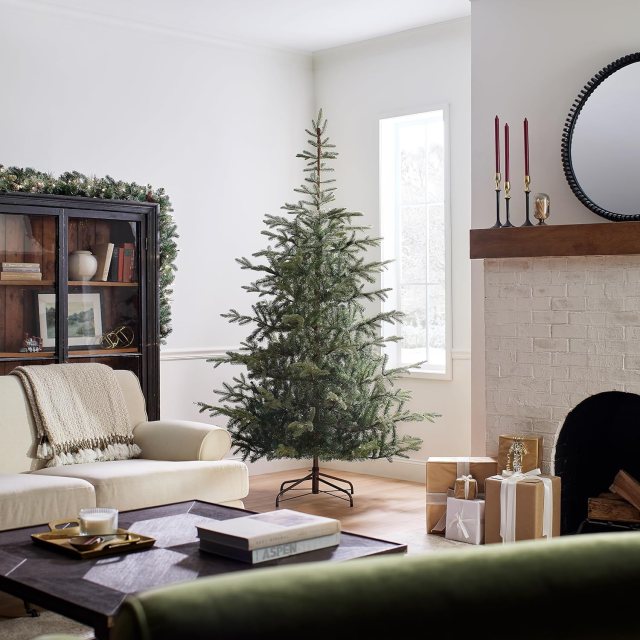 National Tree Company 7.5-foot unlit Norwegian Spruce artificial Christmas tree displayed undecorated in a cozy living room